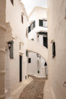 Menorca 'daki Binibeca köyünün dar sokakları. Ahşap elementlerle sıvanmış beyaz duvarlar. İspanya 'da Balear Adaları' nda büyüleyici bir kasaba.