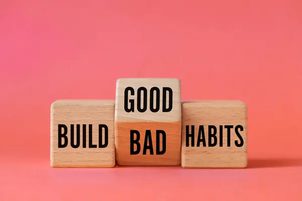 stock image Symbol of building good or bad habits. Turned wooden block and changing the word Build Bad Habits to Build good Habits. Beautiful apricot background. Business concept. Copy space