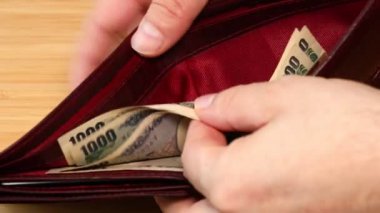 Japon Yeni. Cüzdandaki paraları saymak, az miktarda nakit, ekonomik kriz, harcama analizi, ev bütçesi. Japonya parası