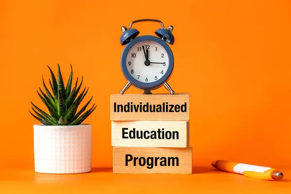 stock image Individualized Education Program. IEP symbol. Program that provides specialized instruction and related services to a child with a diagnosed disability. Orange background, Words on wooden blocks