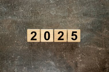 2025. Tahta bloklara yazılmış tarih. Yeni yılın sembolü, iş konsepti, 2025 için planlar ve hedefler. Güzel mermer arkaplan, kopyalama alanı, düz yatış