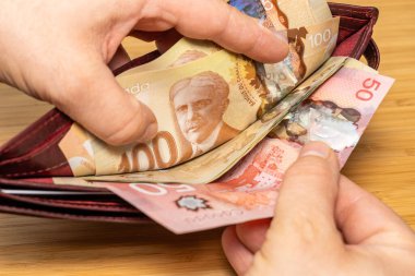 Kanada parası. Kahverengi cüzdandan el çekme, Kanada doları banknotları, finans sektörü konsepti