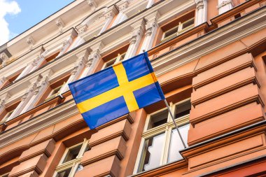 Bir binanın üzerinde İsveç bayrağı dalgalanıyor. İsveç ülke sembolü