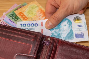 Arjantin parası, cüzdanından 10 bin pezoluk kağıt banknot çıkarılmış. Yeni banknot, Arjantin 10,000. Finansal iş kavramı