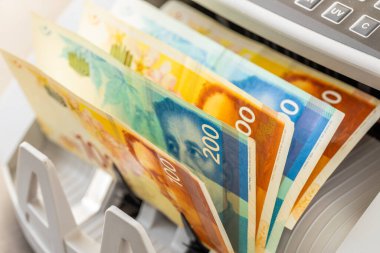 İsrail parası. İsrail şekeli banknotları bir dönüştürücü makinesinde. Finansal iş kavramı, yakın plan.