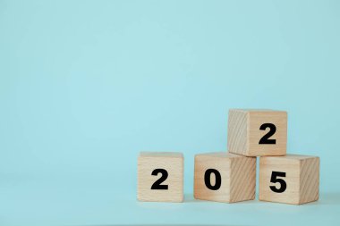 2025 yılı ahşap küplerle. Pastel mavi arkaplan, kopyalama alanı. İş konsepti. Yeni yıl 2025, yeni fırsatlar