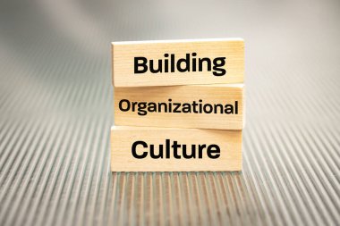 A wooden block with the words Building, Organizational, Culture, Modern approach to working with people in a team, Creative concept, copy space clipart