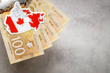 Canadian  money and national emblem, Gray background, copy space, flat lay, Financial background, Canadian dollars banknotes, close up clipart