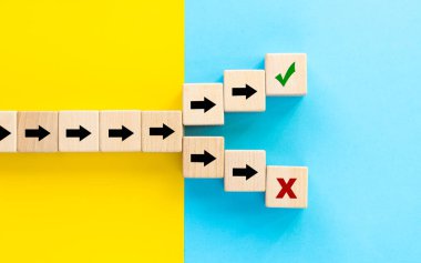 Doğru ya da yanlış seçim. Tahta zarların üzerindeki ok sembolleri farklı yönlere doğru ya da yanlış yolu izlemenin sembolü. Doğru ya da yanlış kararlar vermek, sarı mavi arkaplan, kopyalama alanı