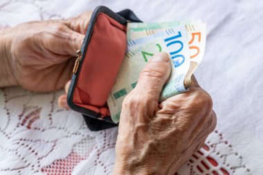 Yaşlı kadın cüzdanında Szwedzkich koron taşıyor. Finansal konsept. Yaşlıların ekonomik durumu