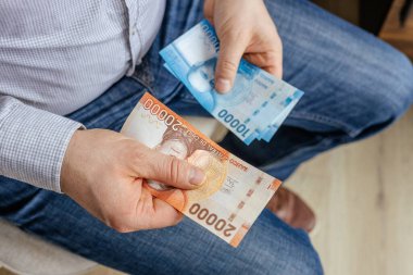 Şili parası. İşadamı Şili pesolarıyla elini uzatıyor. CLP banknotları. Finansal iş kavramı