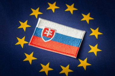 The symbol of Slovakia placed in the middle of the European Union flag. Political Concept. Difficult cooperation of Slovakia with the EU countries. clipart