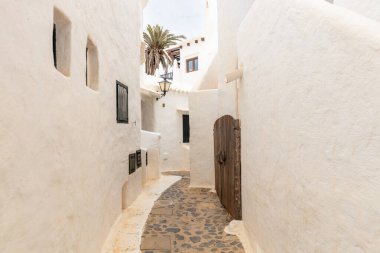 Narrow streets of the beautiful village of Binibeca on Menorca. White plastered house walls with wooden elements. A charming town in Spain on the Balearic Islands clipart