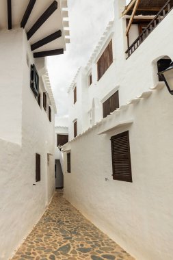 Menorca 'daki güzel Binibeca kasabası. Dar sokaklar ve ahşap elementli beyaz duvarlar, İspanya 'da Akdeniz mimarisi