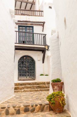 Menorca 'daki Binibeca kasabası. Dar sokaklar ve ahşap elementli beyaz duvarlar, İspanya 'da Akdeniz mimarisi