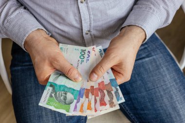 Kolombiya parası. Kolombiyalı iş adamı elinde peso banknotları tutuyor. Finansal ekonomik konsept, iş sembolü