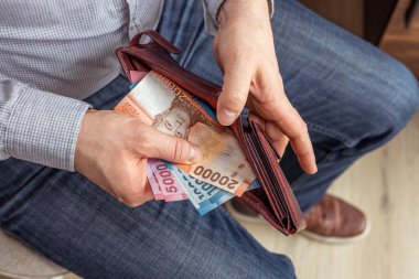 Şili parası. Şilili işadamı cüzdanından peso banknotlar çıkarıyor. Finansal ekonomik konsept, iş sembolü