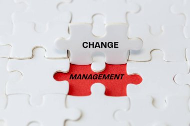 Tabelayı değiştir. Beyaz yapboz parçaları kırmızı arkaplanda değişim yönetim sembolünü gösteriyor. Takım ile iş dönüşümü ve organizasyonel değişim, strateji ve plan.