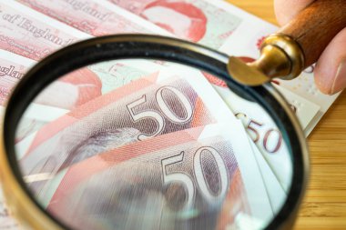 Büyük Britanya 'nın parası. Birleşik Krallık 'ın banknotları büyüteç altında. İngiltere 'nin Finansal Konsepti