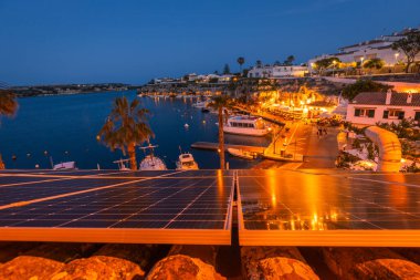 Gün batımından sonra El Castell Menorca. Eski liman manzarası ve barlarla dolu rıhtım manzarası, şehir manzarası. Seyahat konsepti. İspanya turistik merkezleri
