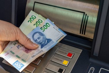 Meksika parası. Bir kadın ATM 'den para çekiyor. Finansal konsept. Meksika Pezosu