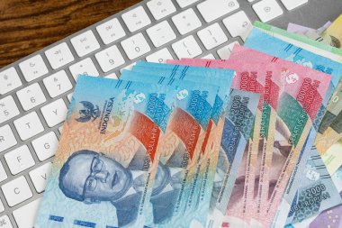 Endonezya finans. İnternetten alışveriş. Finansal iş kavramı. Beyaz bilgisayar klavyesinde Endonezya rupiası. Çevrimiçi ödemeler