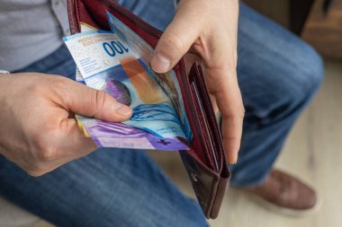 İsviçre parası. İsviçreli işadamı cüzdanından İsviçre frankı çıkardı. Finansal ekonomik konsept, iş sembolü