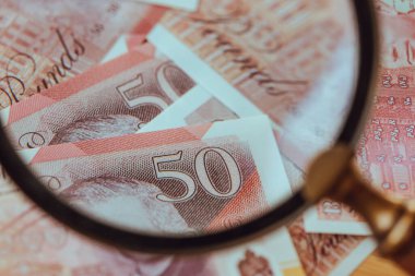 Büyük Britanya 'nın parası. Birleşik Krallık 'ın banknotları büyüteç altında. İngiltere 'nin Finansal Konsepti