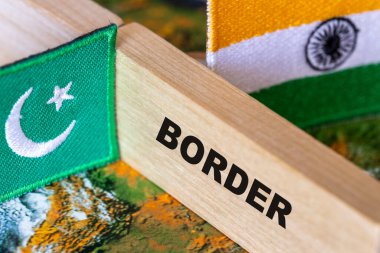 Pakistan-Hindistan sınırı. Hindistan ve Pakistan bayrakları ve iki ülkeyi birbirinden ayıran tahta bloklu sınır sembolü.