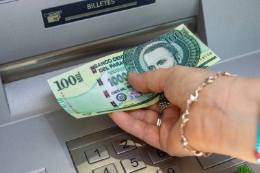 Paraguay parası. Bir kadın ATM 'den 100.000 Paraguay kefil faturası çıkarıyor. Mali konsept