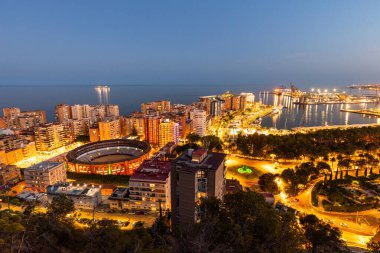 Malaga gece görüşü. İspanya 'nın Malaga şehrinin harika bir şehir manzarası. Gün batımından sonra manzara, boğa güreşi arenası ile şehir panoraması