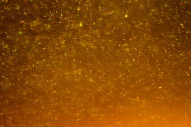 Abstract golden background with sparkles and shadows. Fluidity, waves, glitter, fluid, glitter, shimmer. Gold, glitter, glitters, sequins, golden, sequins, light bulbs, light.