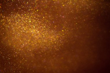 Abstract shiny golden background. Glitter, fluidity, waves, smoke, gold, glitter.
