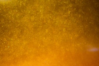 Abstract golden background with sparkles and shadows. Fluidity, waves, glitter, fluid, glitter, shimmer. Gold, glitter, glitters, sequins, golden, sequins, light bulbs, light.