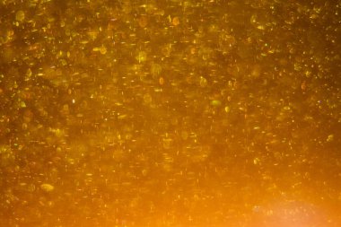 Abstract golden background with sparkles and shadows. Fluidity, waves, glitter, fluid, glitter, shimmer. Gold, glitter, glitters, sequins, golden, sequins, light bulbs, light.