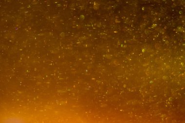Abstract golden background with sparkles and shadows. Fluidity, waves, glitter, fluid, glitter, shimmer. Gold, glitter, glitters, sequins, golden, sequins, light bulbs, light.