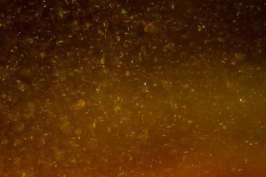 Abstract golden background with sparkles and shadows. Fluidity, waves, glitter, fluid, glitter, shimmer. Gold, glitter, glitters, sequins, golden, sequins, light bulbs, light.