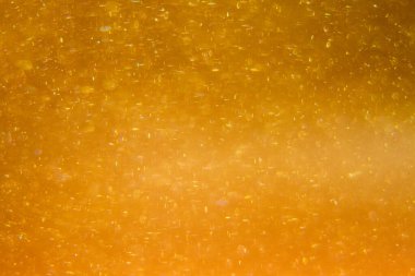 Abstract golden background with sparkles and shadows. Fluidity, waves, glitter, fluid, glitter, shimmer. Gold, glitter, glitters, sequins, golden, sequins, light bulbs, light.