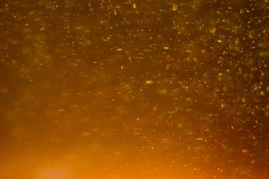 Abstract golden background with sparkles and shadows. Fluidity, waves, glitter, fluid, glitter, shimmer. Gold, glitter, glitters, sequins, golden, sequins, light bulbs, light.
