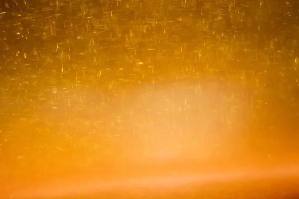 Abstract golden background with sparkles and shadows. Fluidity, waves, glitter, fluid, glitter, shimmer. Gold, glitter, glitters, sequins, golden, sequins, light bulbs, light.