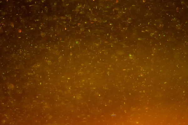 Abstract golden background with sparkles and shadows. Fluidity, waves, glitter, fluid, glitter, shimmer. Gold, glitter, glitters, sequins, golden, sequins, light bulbs, light.