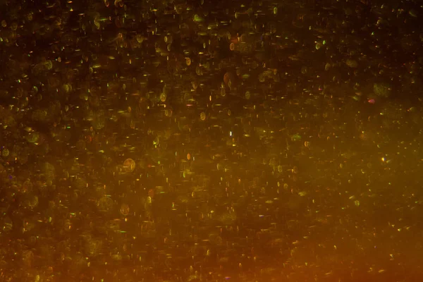 Abstract golden background with sparkles and shadows. Fluidity, waves, glitter, fluid, glitter, shimmer. Gold, glitter, glitters, sequins, golden, sequins, light bulbs, light.