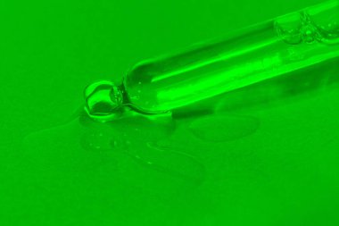 Yeşil zemin, serum, serum, serum, jel, vitamin, su ve yağ damlatan sıvı, yağ içeren kozmetik pipet. Doğal Kozmetik