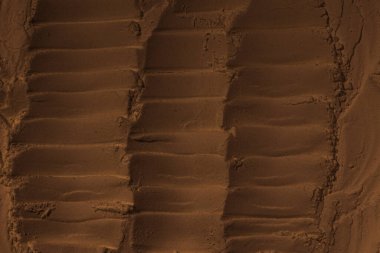 Kumun yüzeyi, kil, toprak. Tekerlek izleri, lastik izleri. Kraterler, çöküntüler, çıkıntılar. Mars. GezegenName