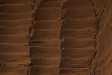 Kumun yüzeyi, kil, toprak. Tekerlek izleri, lastik izleri. Kraterler, çöküntüler, çıkıntılar. Mars. GezegenName