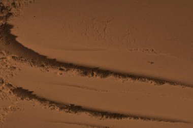 Kumun yüzeyi, kil, toprak. Tekerlek izleri, lastik izleri. Kraterler, çöküntüler, çıkıntılar. Mars. GezegenName