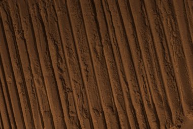 Kumun yüzeyi, kil, toprak. Tekerlek izleri, lastik izleri. Kraterler, çöküntüler, çıkıntılar. Mars. GezegenName