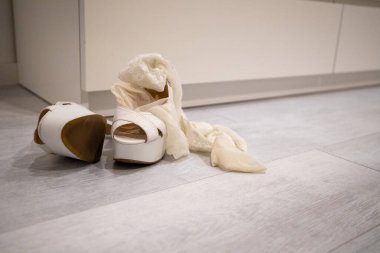 Giyinmek için beyaz ahşap zeminde kırmızı topuklu ayakkabılar.