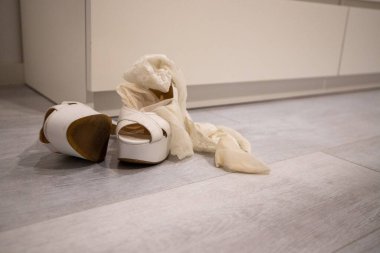 Giyinmek için beyaz ahşap zeminde kırmızı topuklu ayakkabılar.