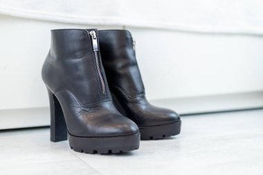 Beyaz bir dolabın önünde yüksek topuklu siyah çizmeler. Yüksek kalite fotoğraf